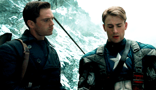 Young Captain America turning to look at Bucky Barnes on a snowy mountainside.
